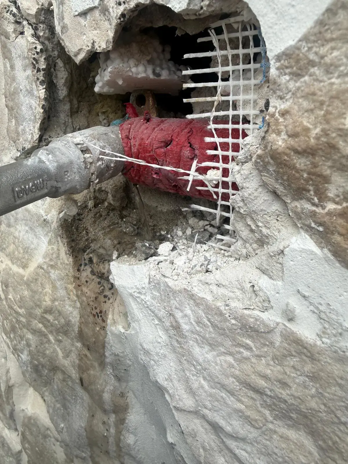 Freigelegter Rohrbruch mit Wasseraustritt an einer isolierten Druckleitung
